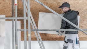 Homme à lunettes plaçant un panneau d'isolation